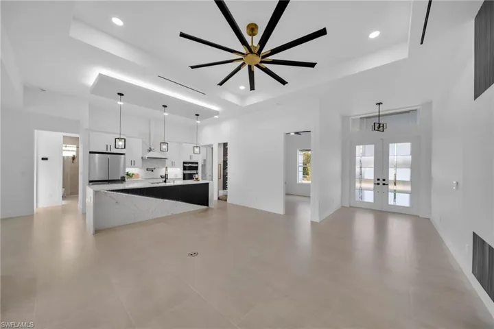 Kitchen with a tray ceiling, french doors, freestanding refrigerator, and a sink