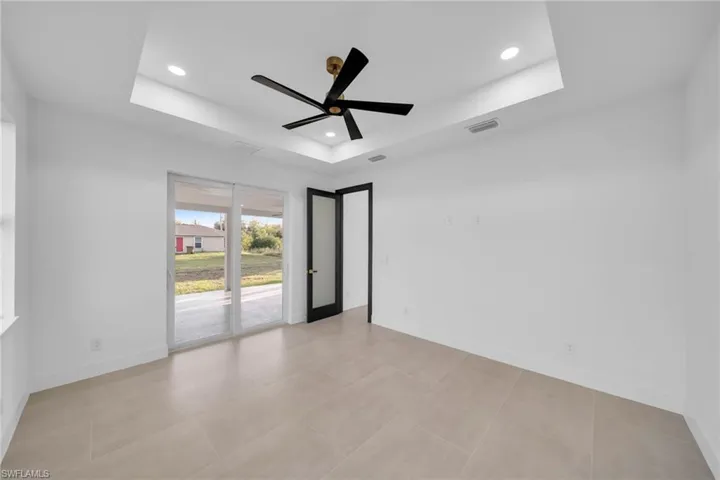 Empty room with recessed lighting, a tray ceiling, baseboards, and a ceiling fan