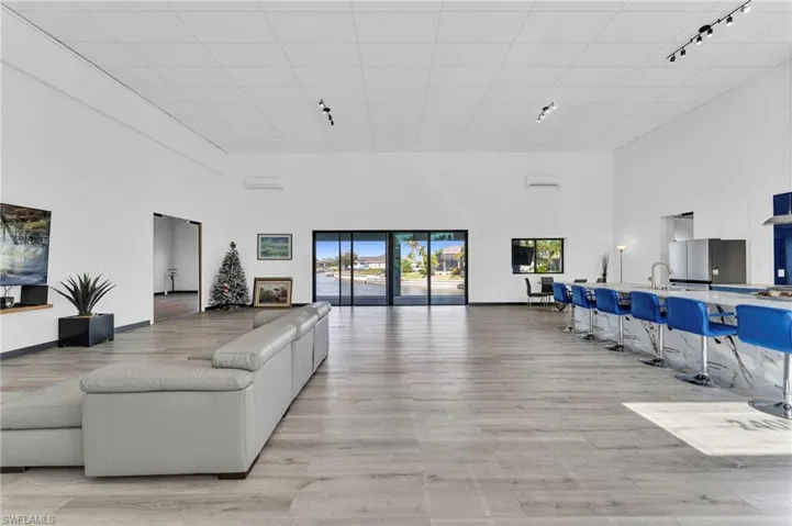 Living area featuring a high ceiling, track lighting, and light wood-type flooring