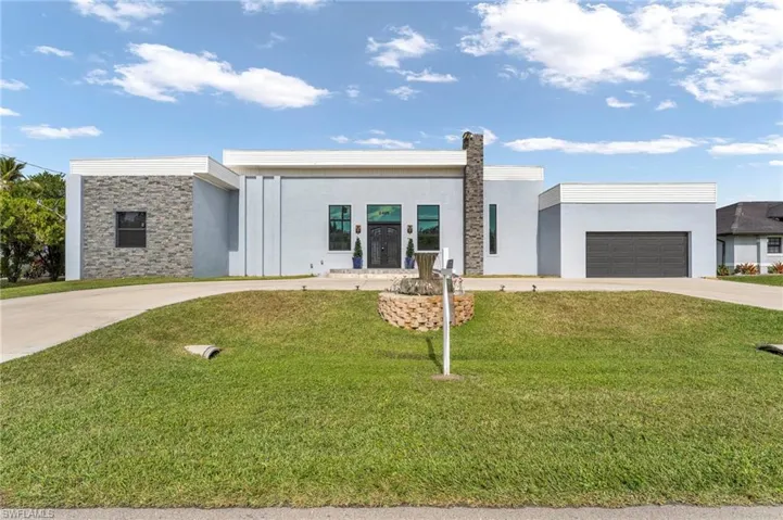 Contemporary home with concrete driveway, stucco siding, a front lawn, and stone siding