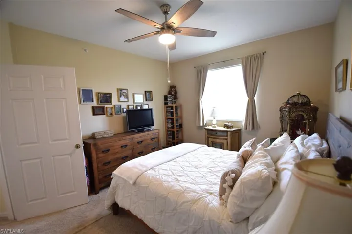 Bedroom with light carpet and a ceiling fan