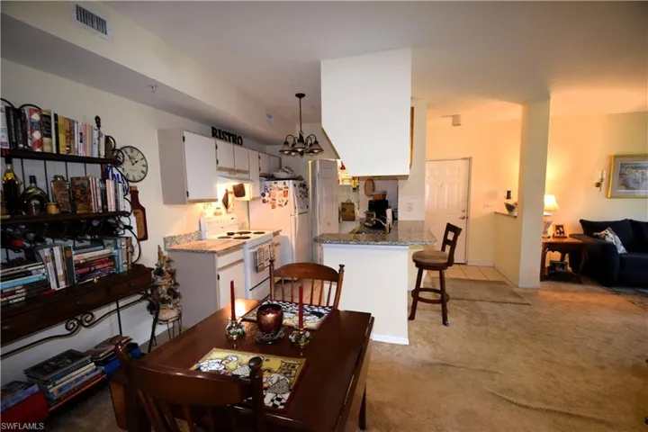 Dining room featuring light carpet and a chandelier