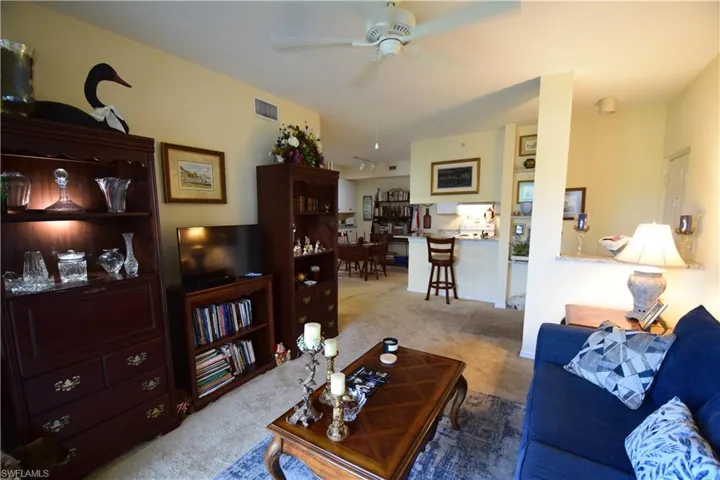 Carpeted living area featuring a ceiling fan
