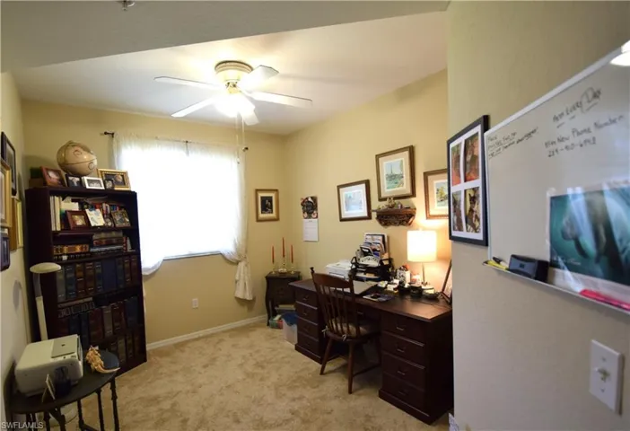 Office space featuring a ceiling fan and light colored carpet
