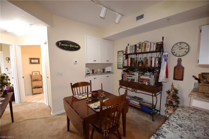 Dining area featuring light carpet, track lighting, and baseboards