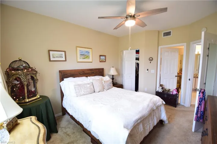Bedroom featuring light carpet, ceiling fan, and baseboards
