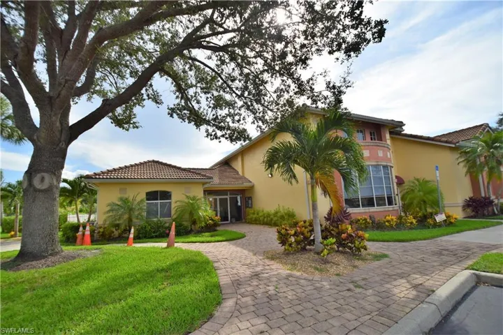 Mediterranean / spanish-style house with curved driveway, stucco siding, a front yard, and a tiled roof