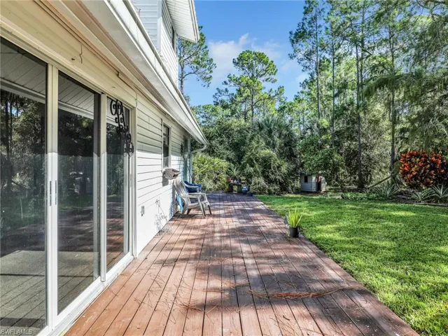 Wooden deck with a lawn and view of scattered trees