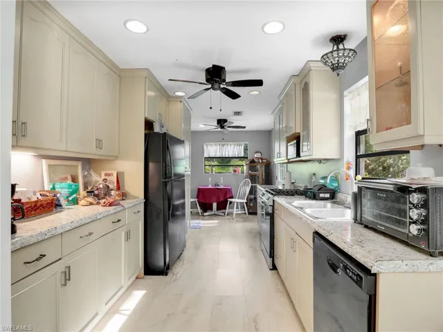 Kitchen featuring cream cabinetry, black appliances, ceiling fan, healthy amount of natural light, and recessed lighting