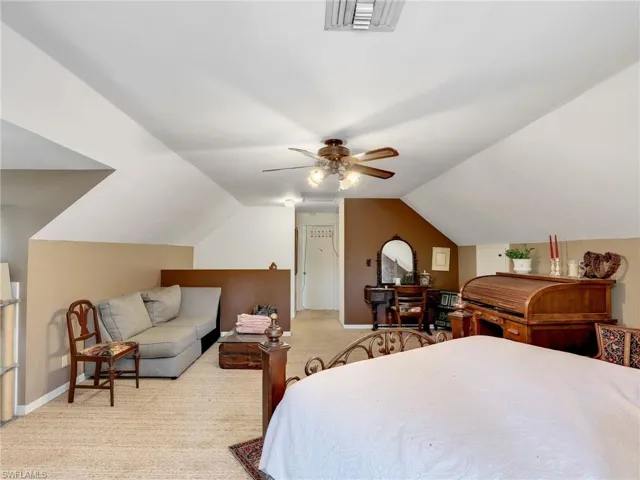 Bedroom featuring lofted ceiling, light colored carpet, and ceiling fan