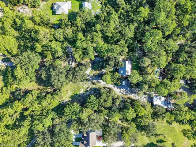 Aerial view of property's location featuring a heavily wooded area