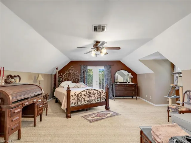 Bedroom with light colored carpet, lofted ceiling, ceiling fan, and access to outside