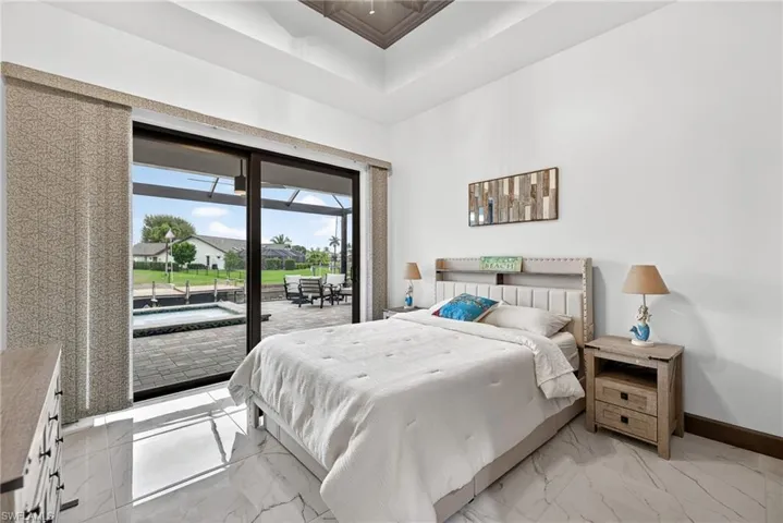 Bedroom with access to exterior, light marble finish flooring, and a sunroom