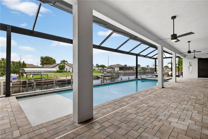 View of pool with a lanai, a patio, boat lift, and a sunroom