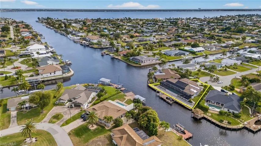 Aerial view of property's location with a nearby body of water and nearby suburban area