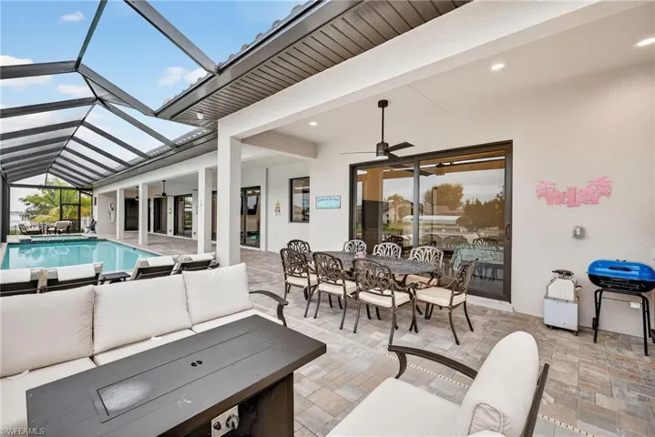View of patio featuring an outdoor living space, outdoor dining space, a ceiling fan, and a sunroom