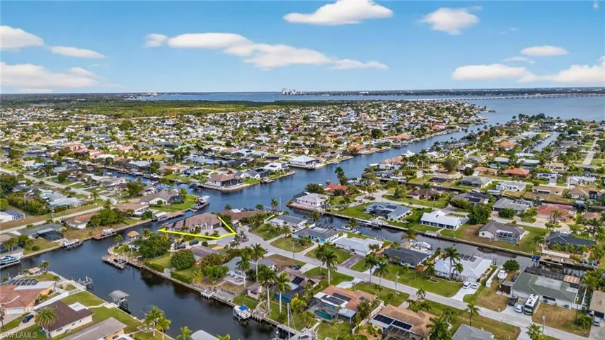 Aerial view of property's location featuring a large body of water and nearby suburban area