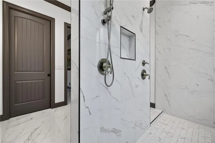 Full bathroom featuring a marble finish shower and marble finish floors