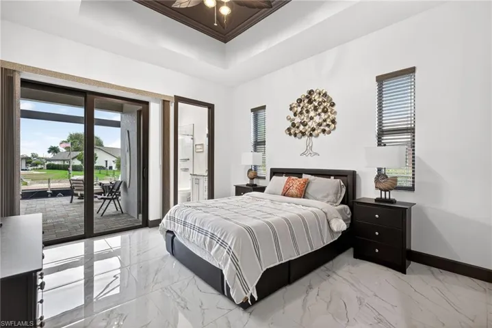 Bedroom with light marble finish flooring, access to outside, and multiple windows