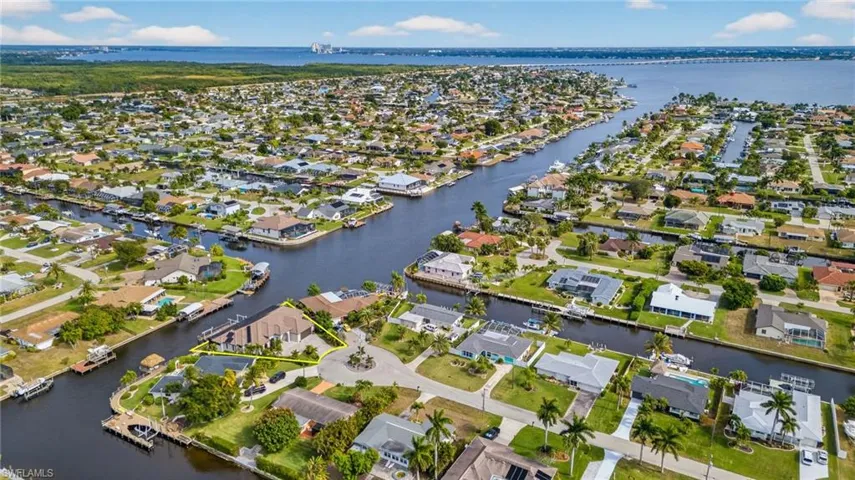 Aerial view of property and surrounding area with a large body of water and nearby suburban area