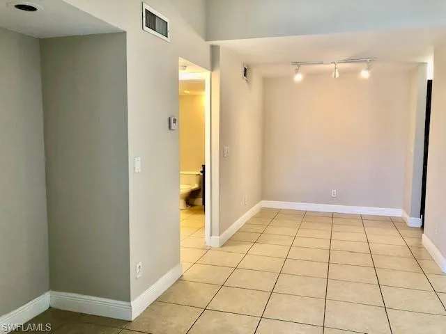 Spare room with light tile patterned floors and track lighting
