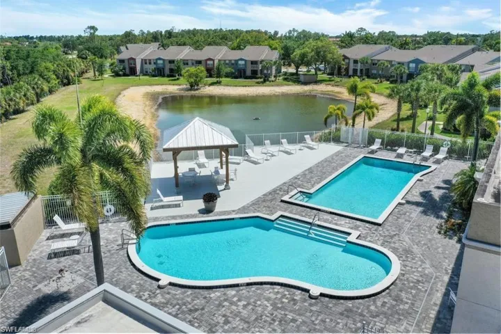 Community pool with a gazebo, a patio, a water view, and view of scattered trees