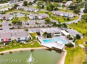 Drone / aerial view of a nearby body of water and a pool area