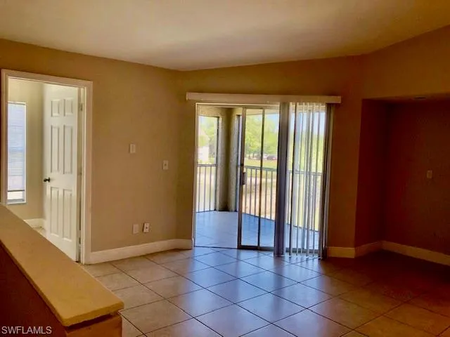 Empty room with baseboards and light tile patterned floors