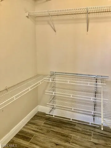 Walk in closet with wood finish floors