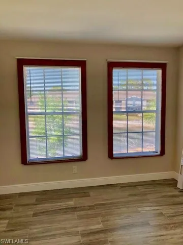 Spare room with baseboards and wood finished floors