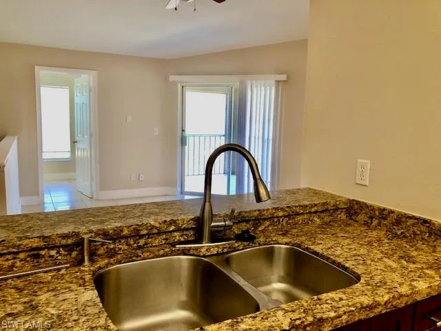 Kitchen view of dark stone countertops and ceiling fan