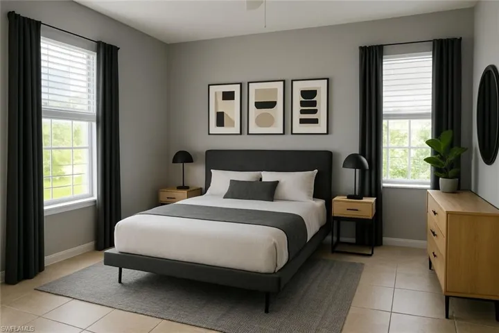 Bedroom with light tile patterned floors and a ceiling fan.Staging