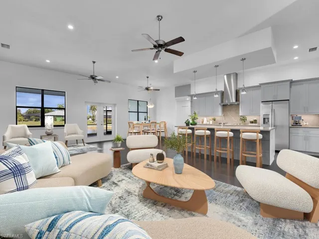Living room with recessed lighting, visible vents, wood finished floors, and ceiling fan