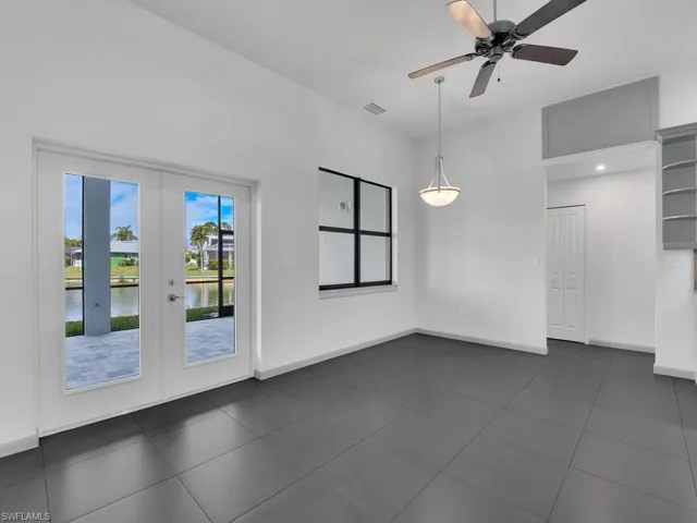 Unfurnished room featuring a ceiling fan, french doors, visible vents, and baseboards