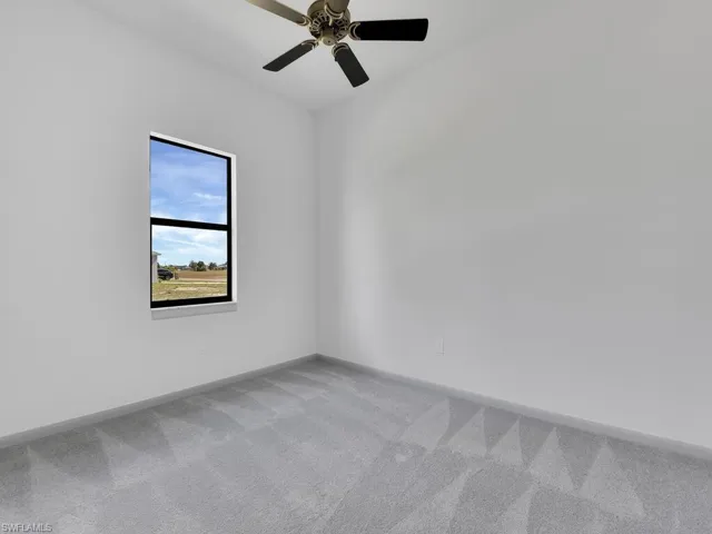 Empty room with baseboards, carpet, and a ceiling fan