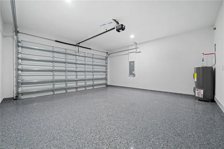 Garage featuring water heater and electric panel