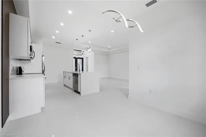 Kitchen featuring a kitchen island with sink, white cabinetry, recessed lighting, light stone countertops, and stainless steel appliances
