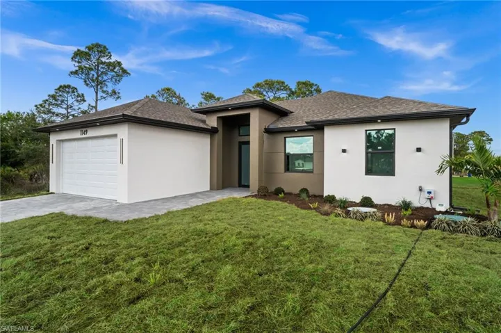 Prairie-style house with a front lawn, an attached garage, and stucco siding