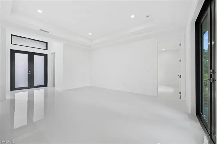 Spare room featuring french doors, recessed lighting, and a raised ceiling