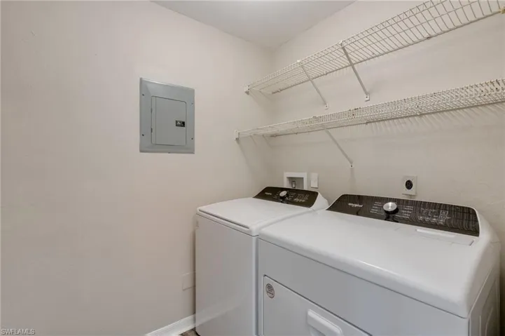Laundry room with electric panel and washing machine and dryer