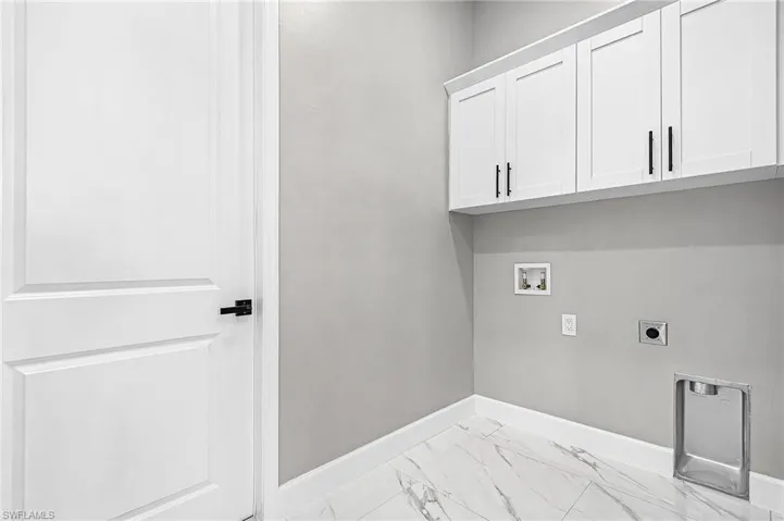 Laundry area with washer hookup, electric dryer hookup, light porcelain finish floors, and cabinet space