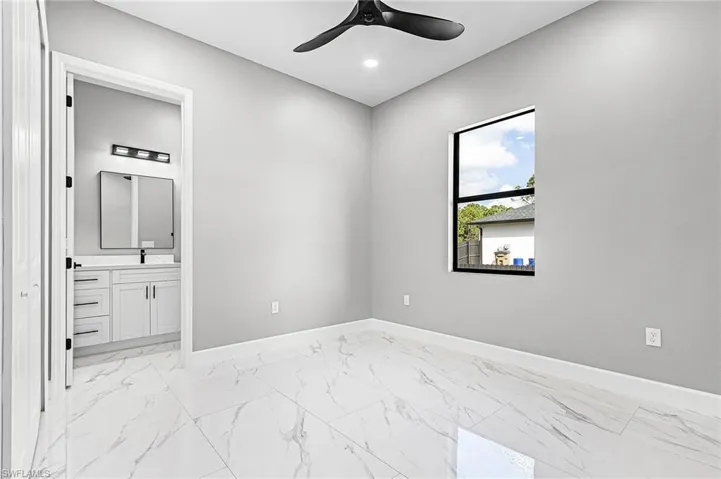 Guest Bedroom with en suite. Light porcelain finish flooring, ceiling fan, and recessed lighting