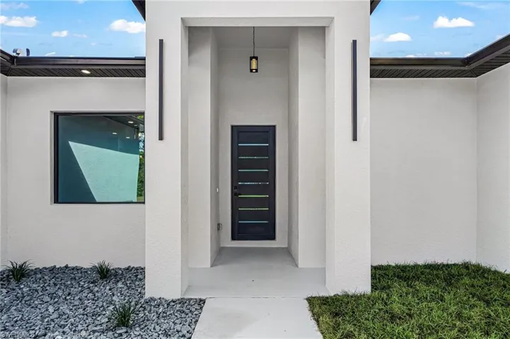 Doorway to property featuring stucco siding