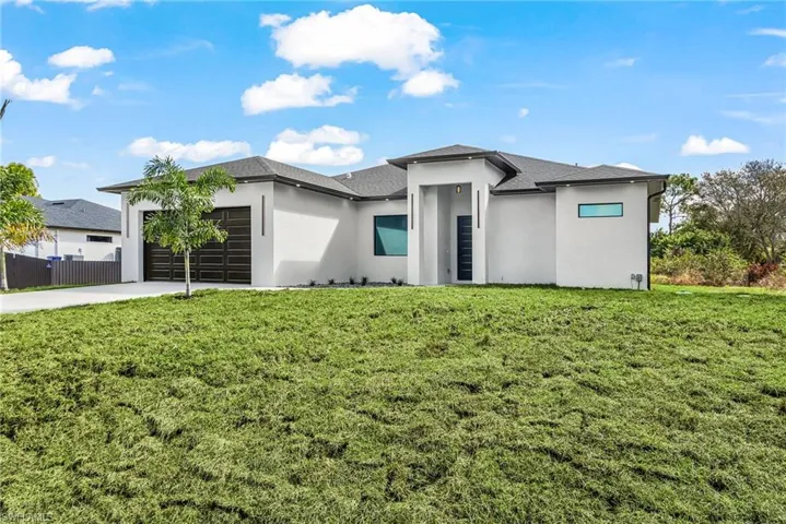 Prairie-style home featuring stucco siding, a garage, concrete driveway, and a shingled roof
