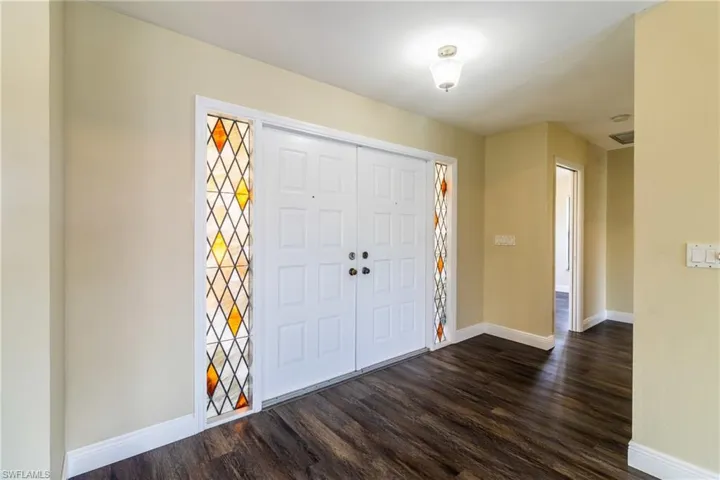 Entrance foyer with dark wood-type flooring and baseboards