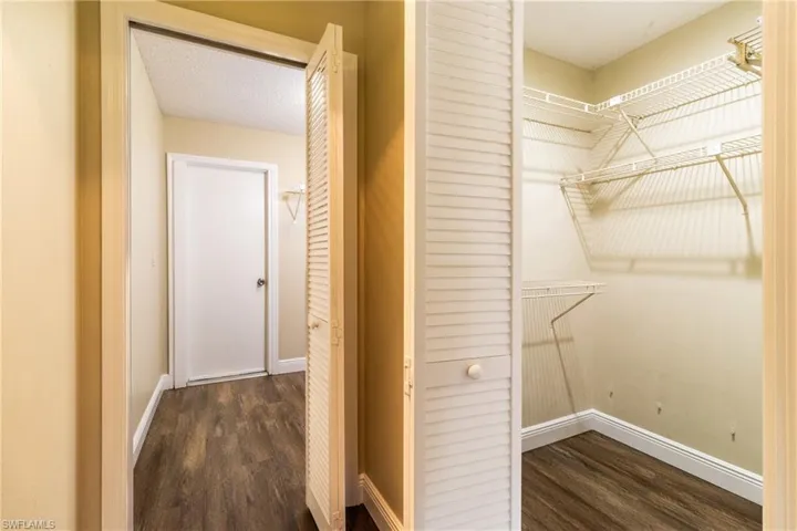 Walk in closet featuring dark wood-style flooring