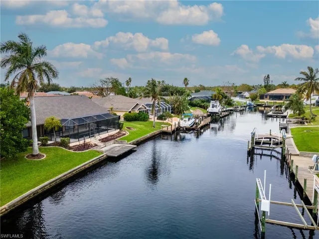 Water view with a boat dock, nearby suburban area, and boat lift