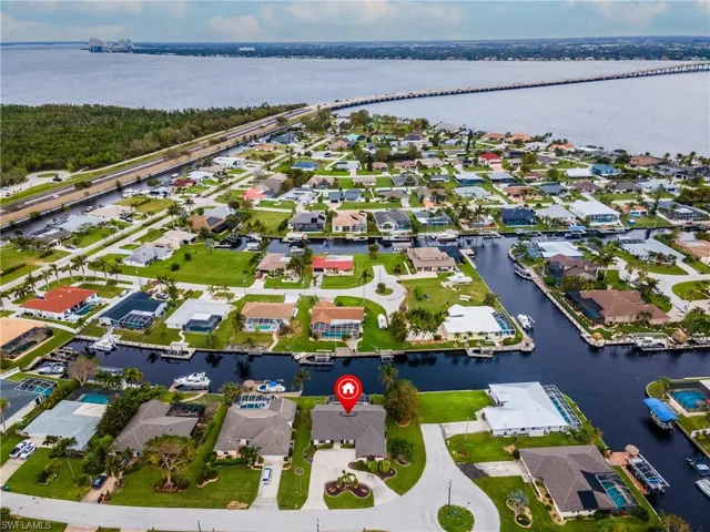 Aerial view of property and surrounding area featuring a large body of water and nearby suburban area