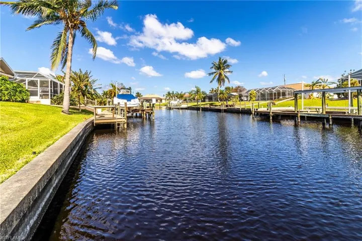 Dock area with a residential view, a water view, a sunroom, and boat lift