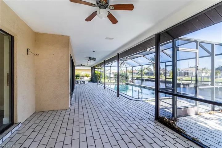Swimming pool with a lanai, a sunroom, a patio, a water view, and a residential view